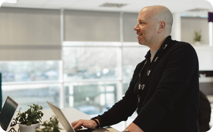 Onecom employee standing using laptop