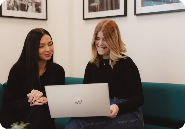 two Onecom employees looking at laptop together