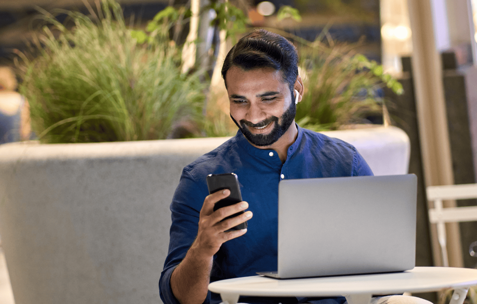 man-on-phone-and-laptop-modern-workspace